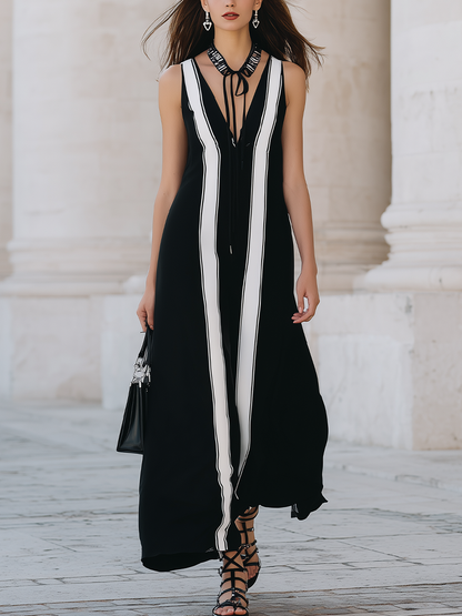 Black Sleeveless Long Dress With Black And White Striped Panels.