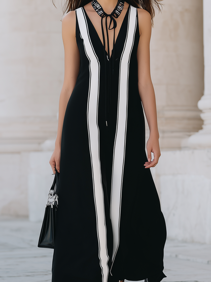 Black Sleeveless Long Dress With Black And White Striped Panels.